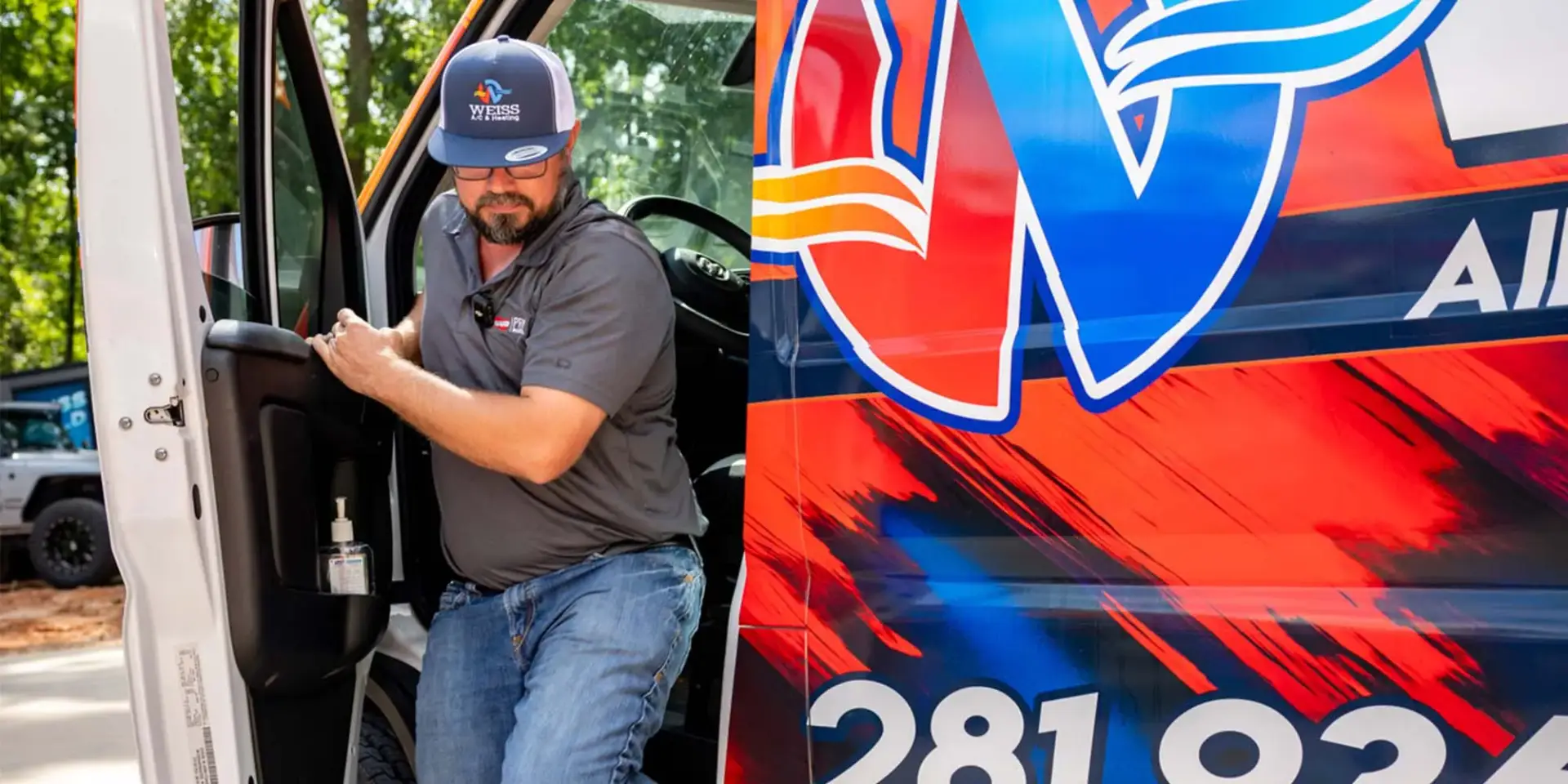A uniformed Weiss Air Conditioning & Plumbing technician wearing a logo cap steps out of a company van.