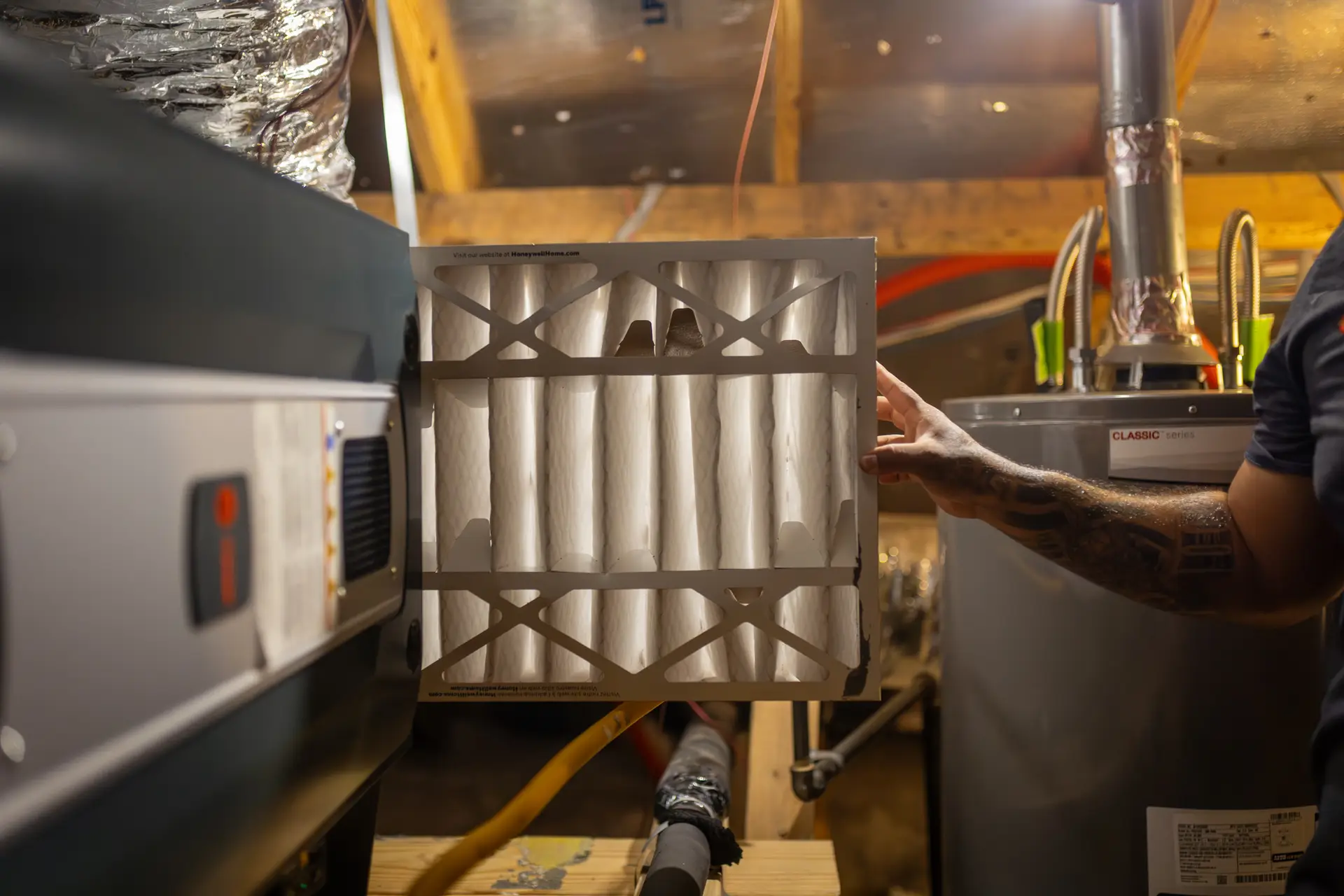 Technician replacing a dirty HVAC air filter during preventative maintenance to improve indoor air quality and system efficiency.