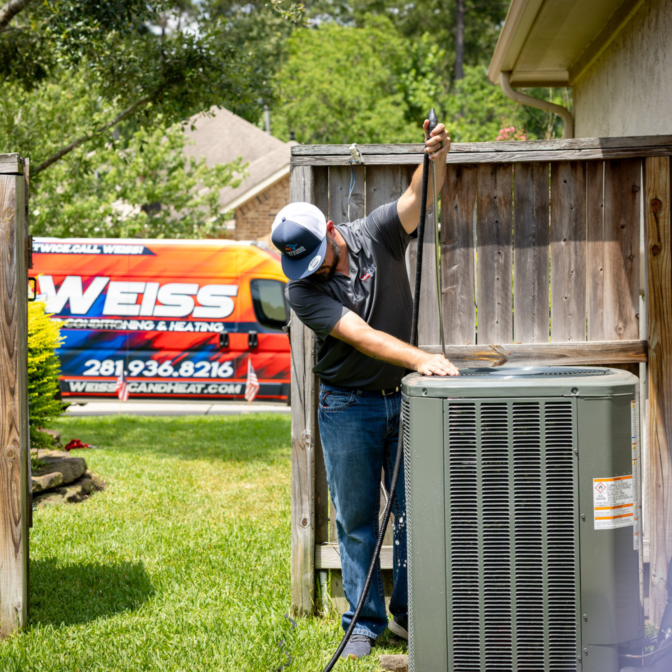 Technician from Weiss Air Conditioning and Heating servicing a residential HVAC unit, showcasing expert heating and cooling solutions.