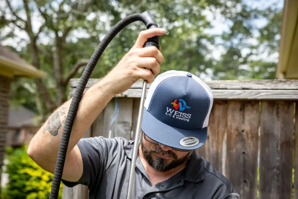 Weiss AC and Plumbing tech doing ac maintenance