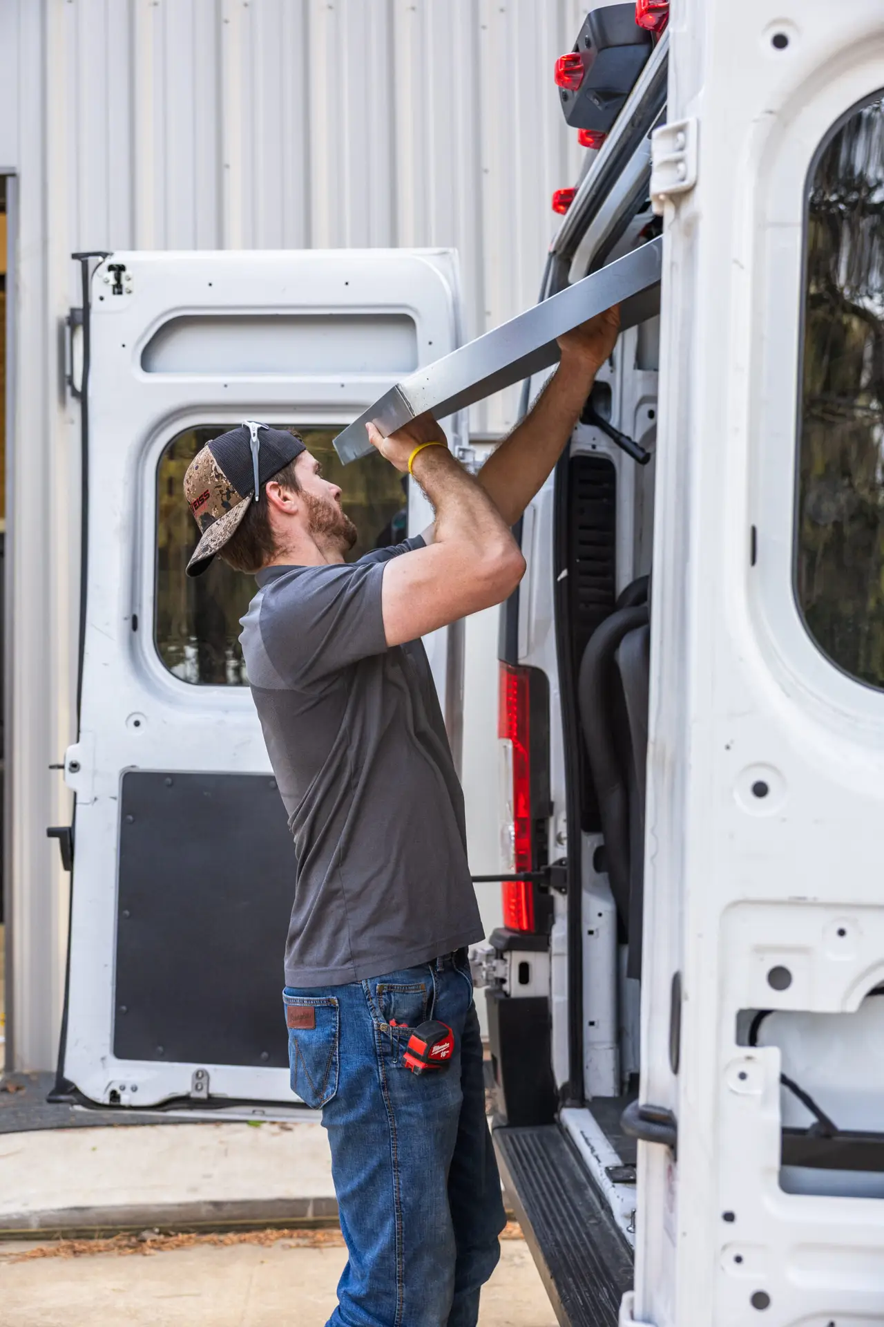 A Weiss Air Conditioning & Plumbing technician loading professional tools in a fully stocked service van in Montgomery County.