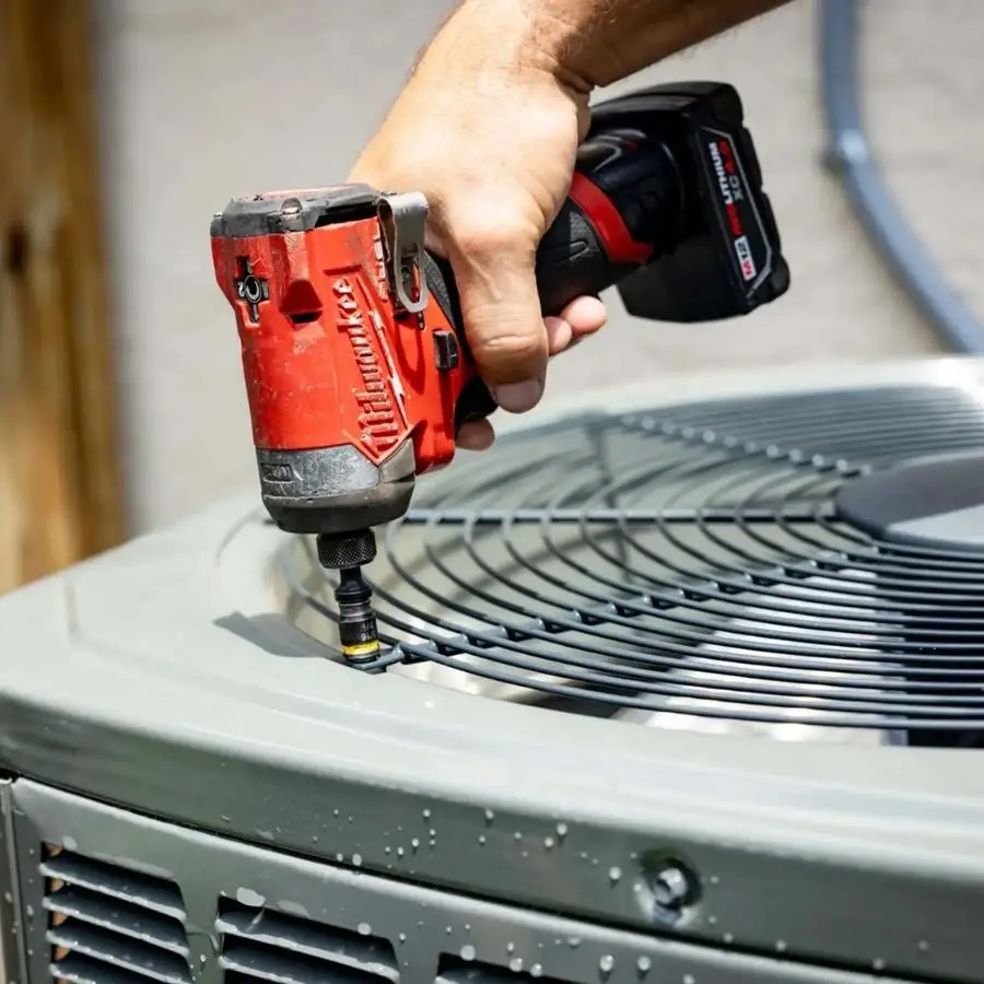 Weiss AC and Plumbing tech fixing an ac unit in Tomball