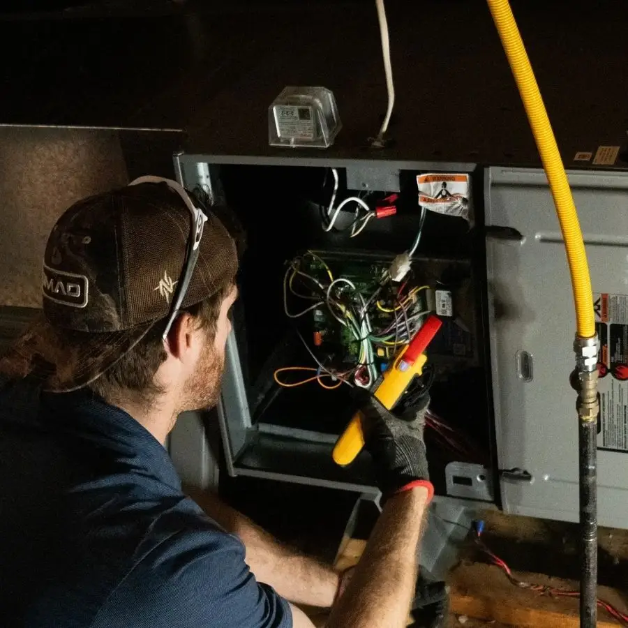 A Weiss Air Conditioning & Plumbing specialist performing a safety and electrical commission for a new heating system installation in Montgomery County.