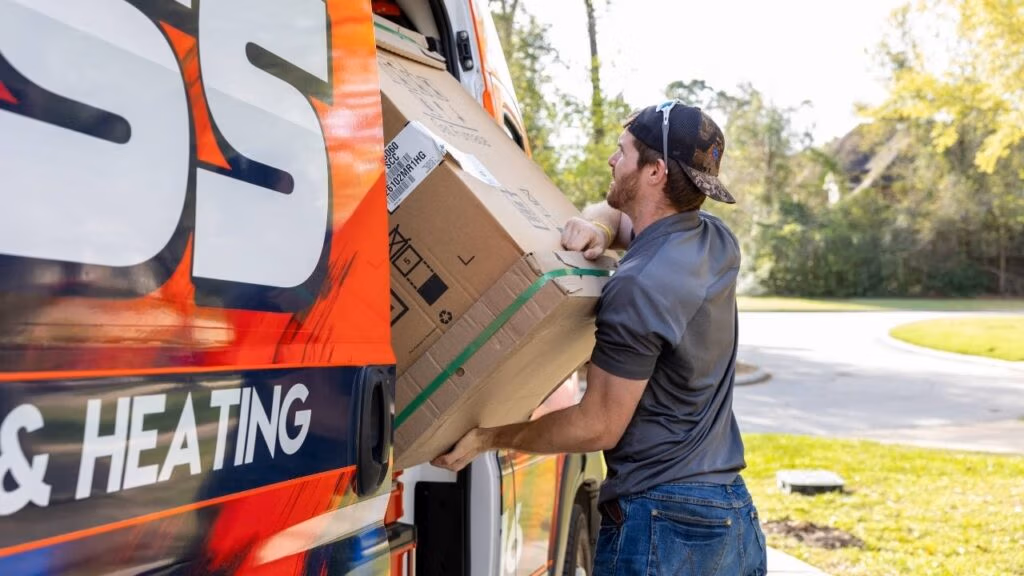 Weiss AC and Plumbing technician unloading a new ac unit at a residential job in Conroe, TX.
