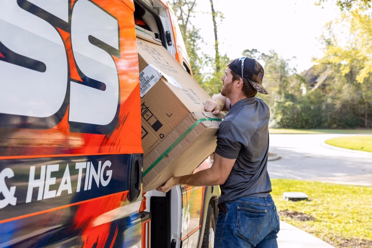 Weiss AC and Plumbing technician unloading a new ac unit at a residential job in Conroe, TX.