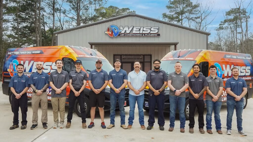 weiss ac and plumbing technicians and owner standing in front of their building.