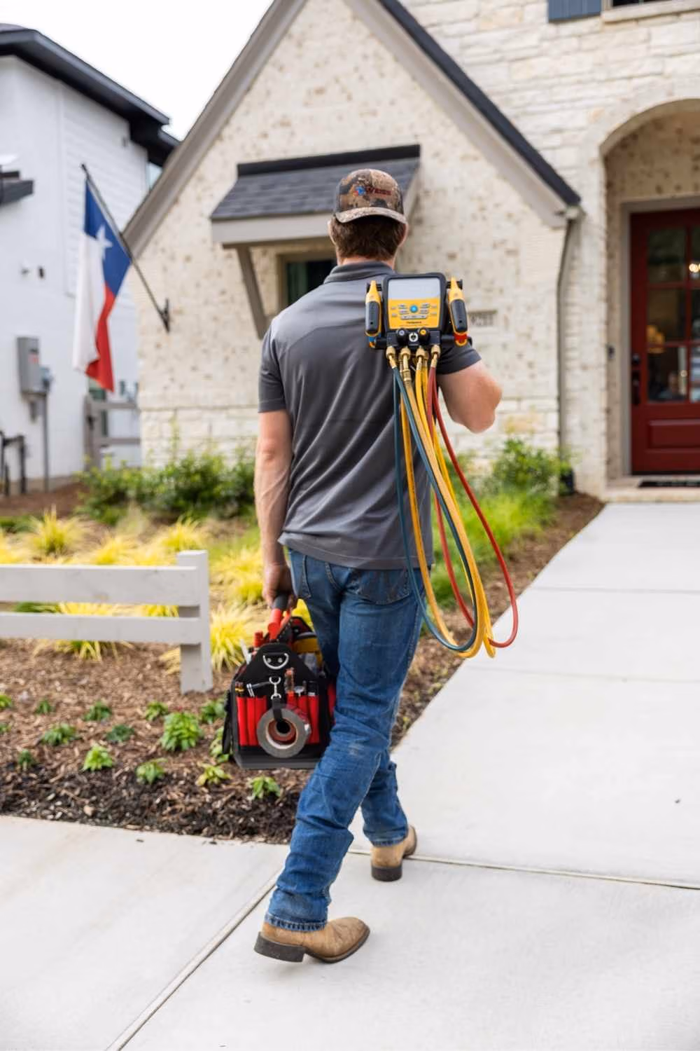 Professional AC technician performing a repair on a central air conditioning unit for a home in The Woodlands, TX.