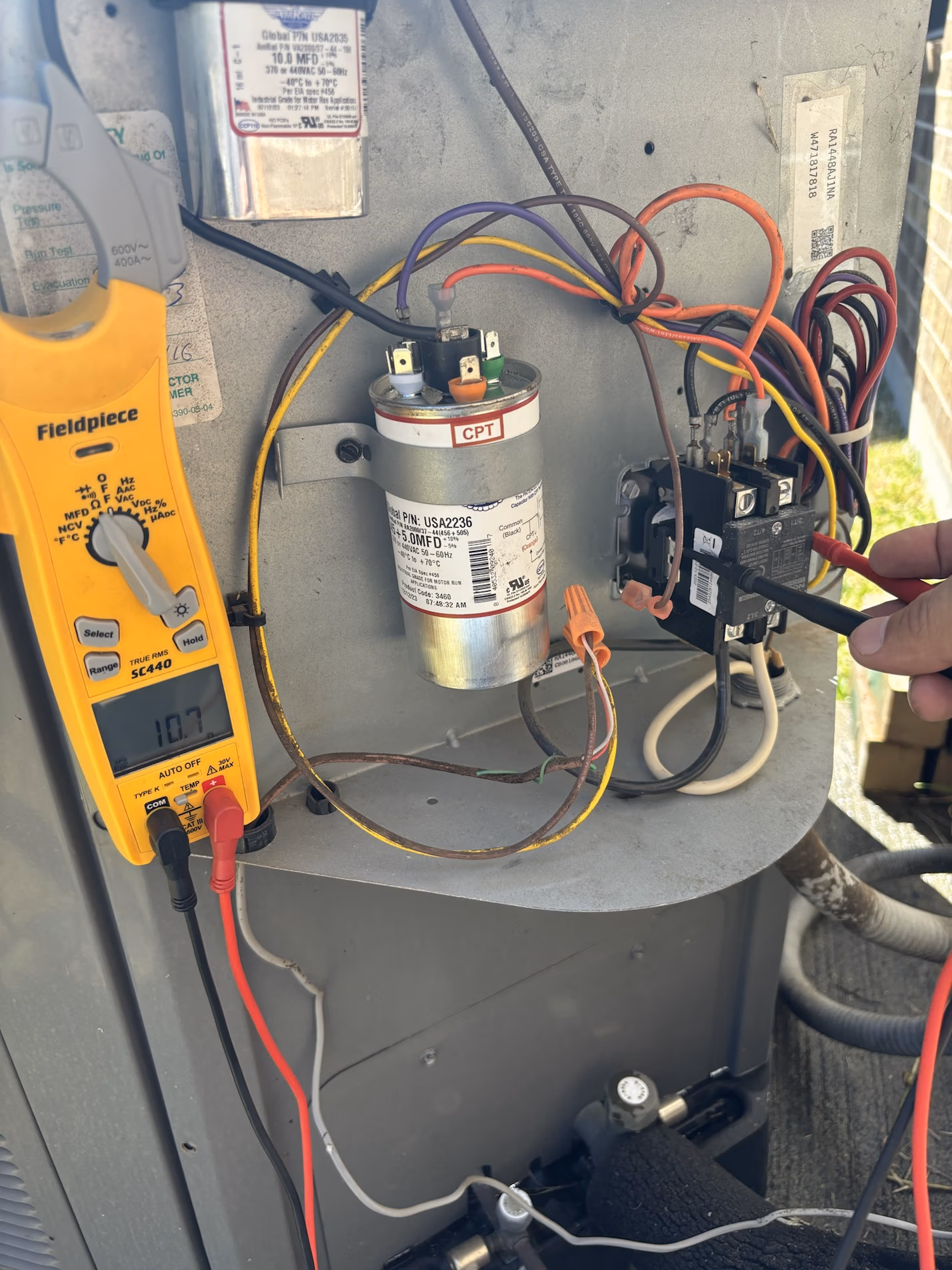 HVAC technician testing an AC capacitor during an ac repair in Montgomery, TX