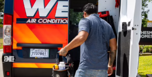 Weiss A/C & Heating technician grabbing tools from a company service van to begin a home heater replacement in Conroe, TX.