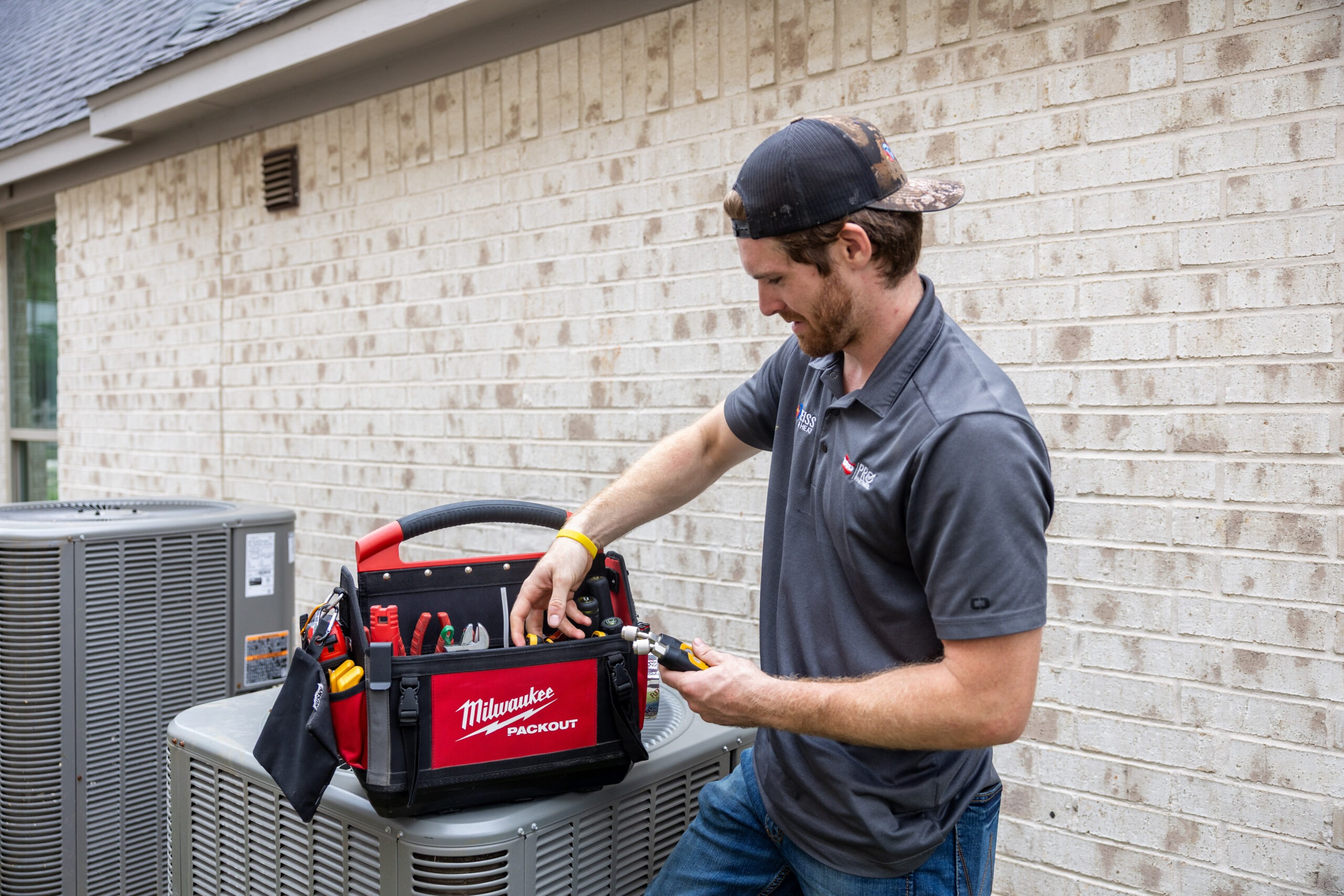 Weiss AC & Plumbing tech performing maintenance on an outside unit for a customer in Montgomery County, TX.
