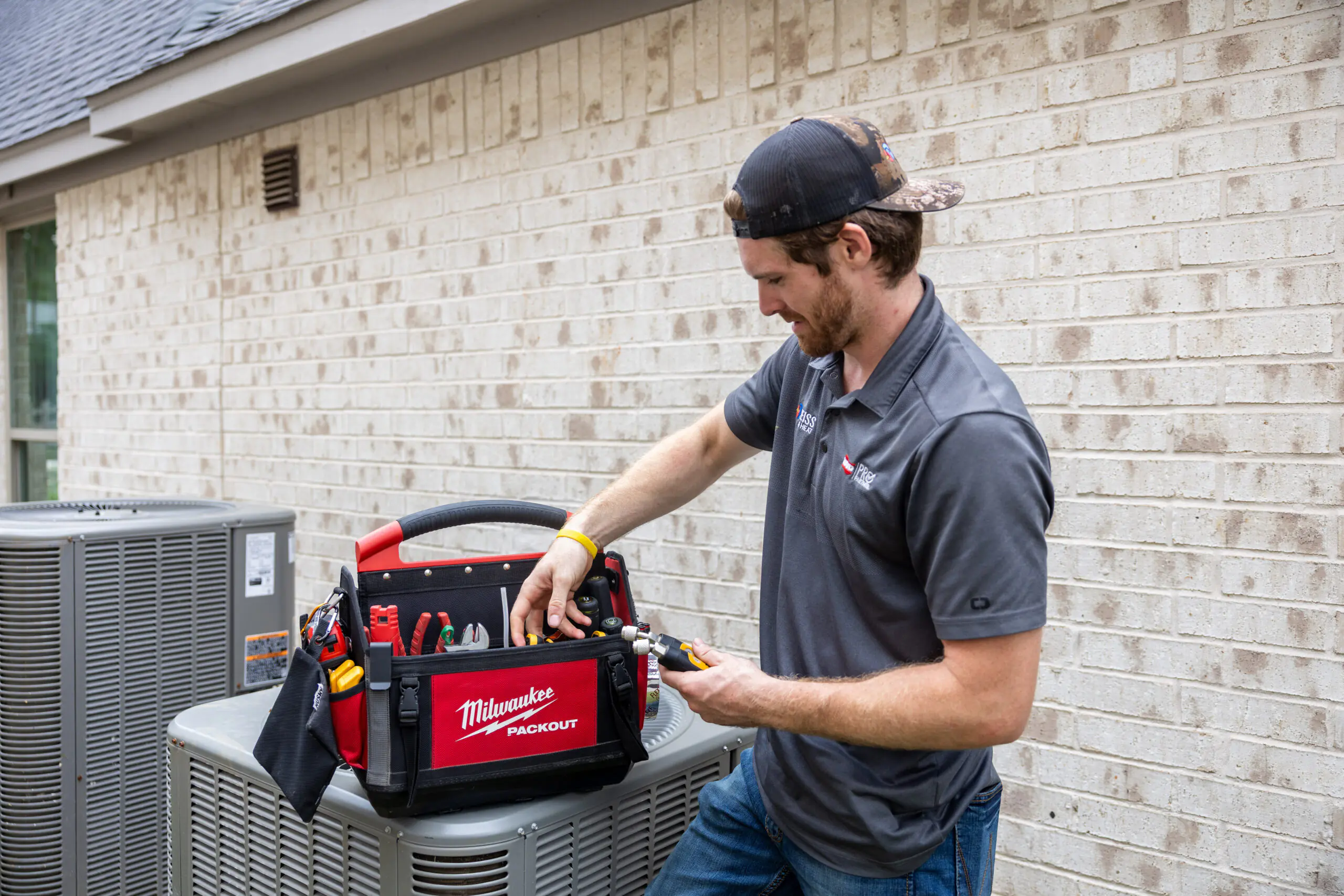 Weiss AC & Plumbing tech performing maintenance on an outside unit for a customer in Montgomery County, TX.